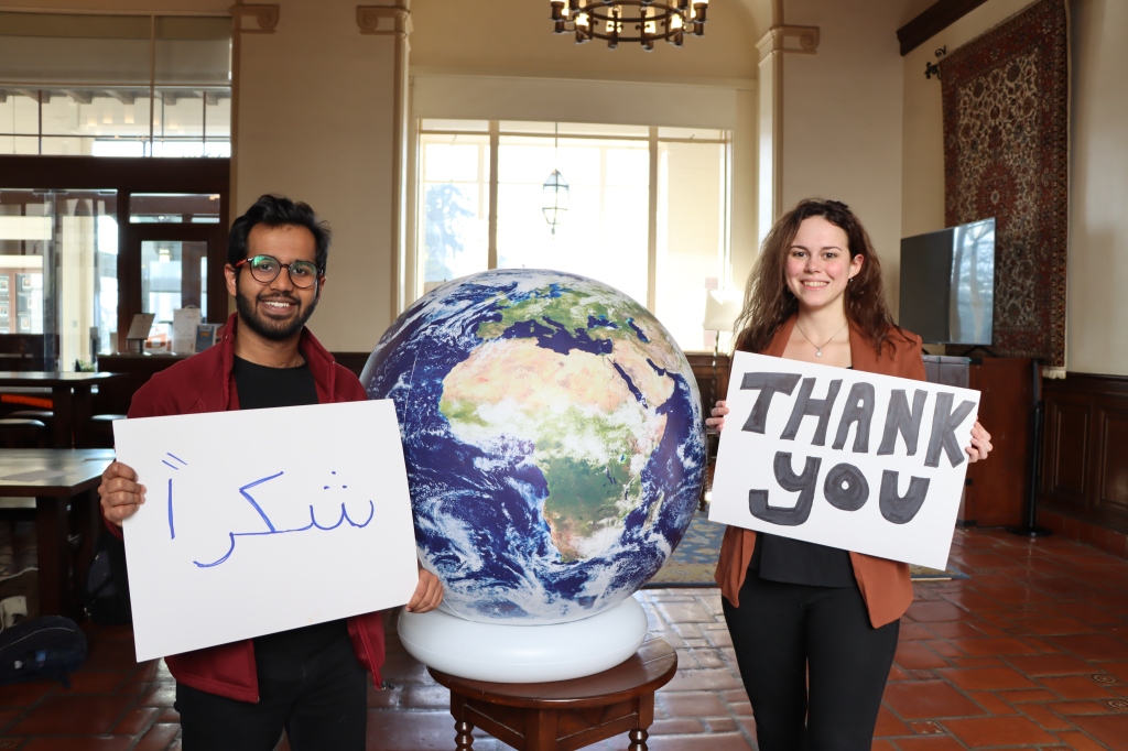 Resident holding Thank You signs by our globe