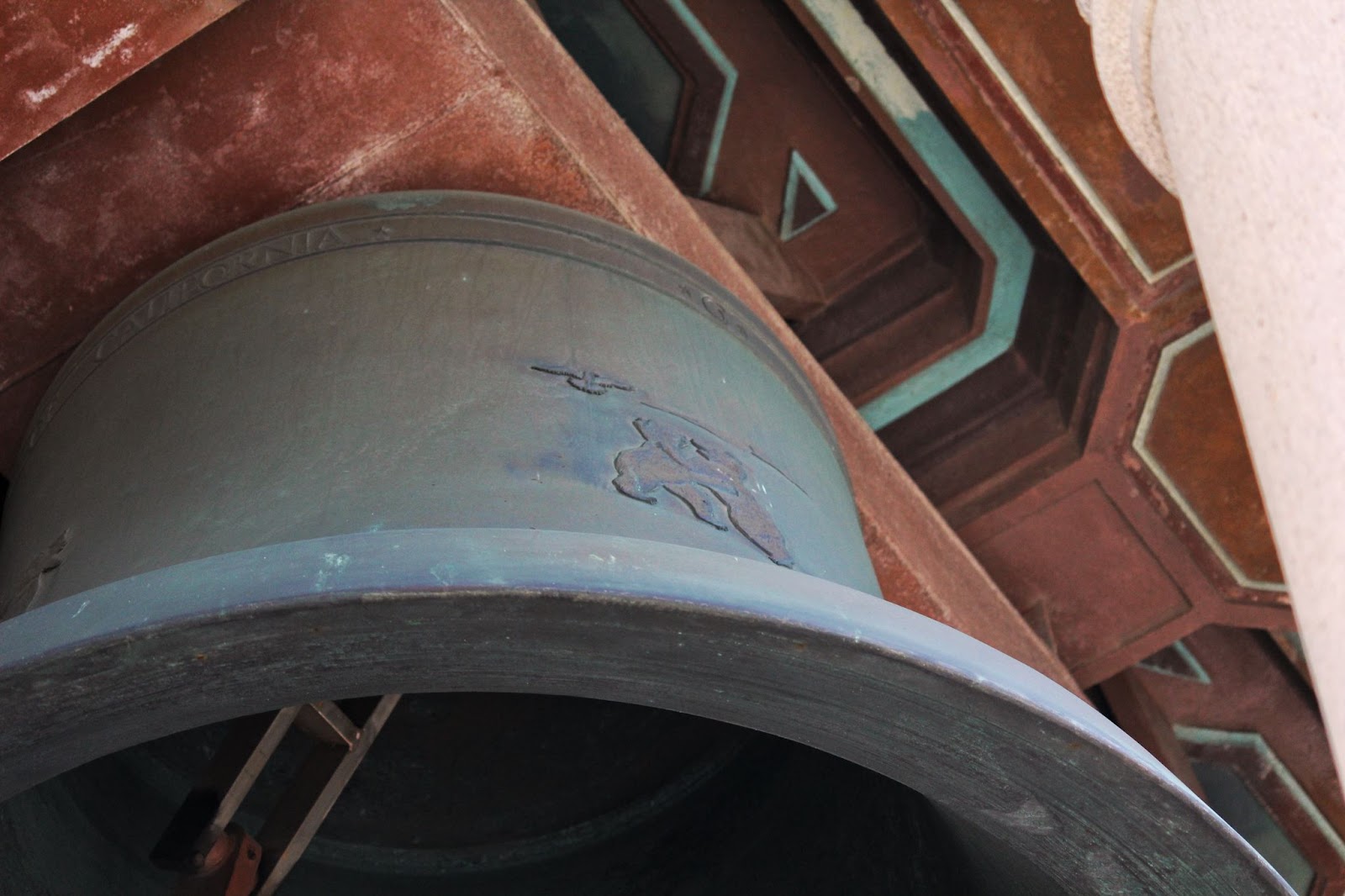 A relief sculpture of two bears hugging on a bell. 