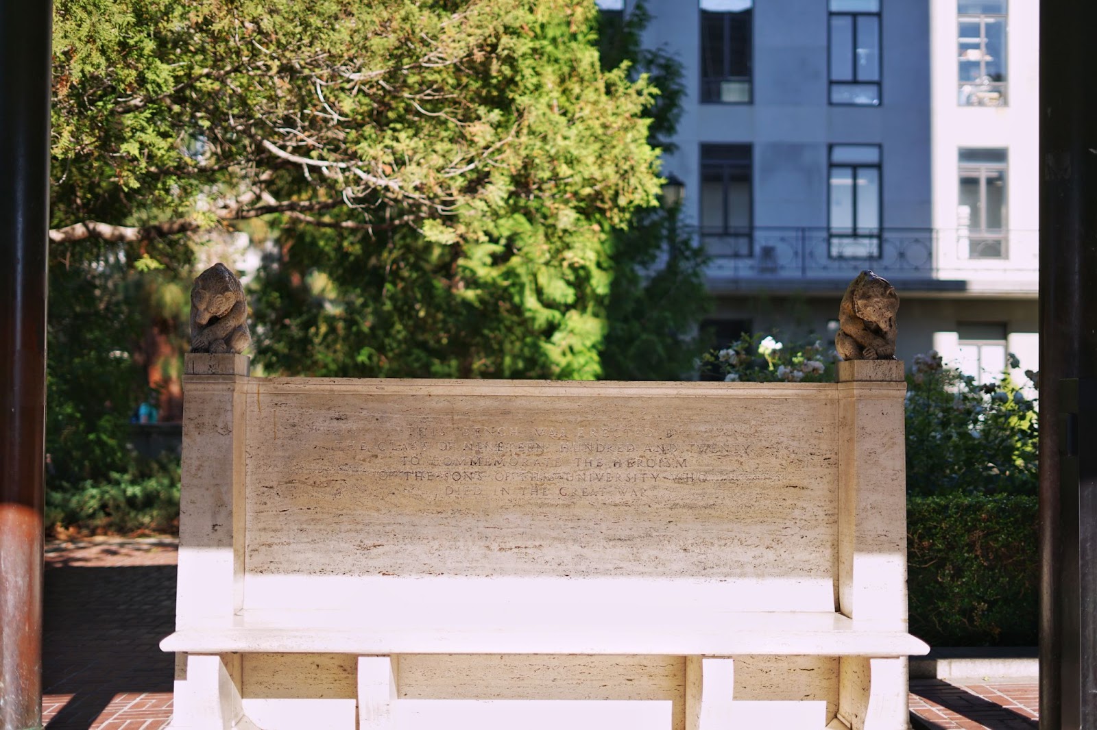 A bench with two bear statues on either end. 