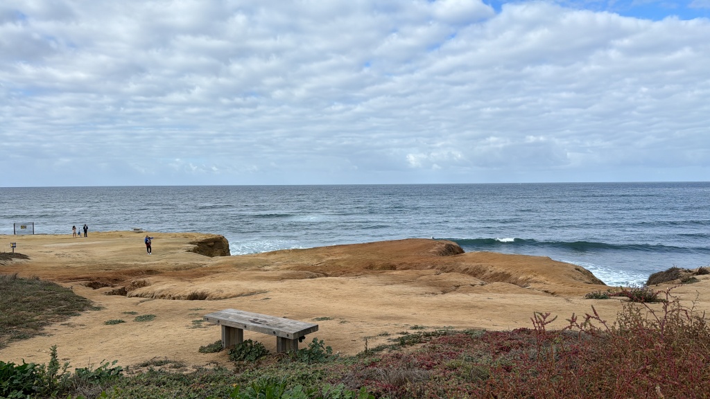 A rocky beach in the foreground and the ocean in the backdrop.