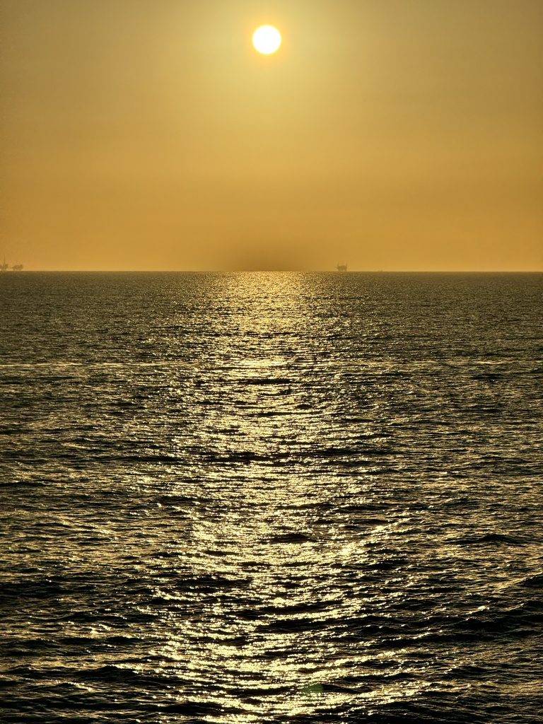 A photo of the reflection of the sun reflecting off the ocean waves.