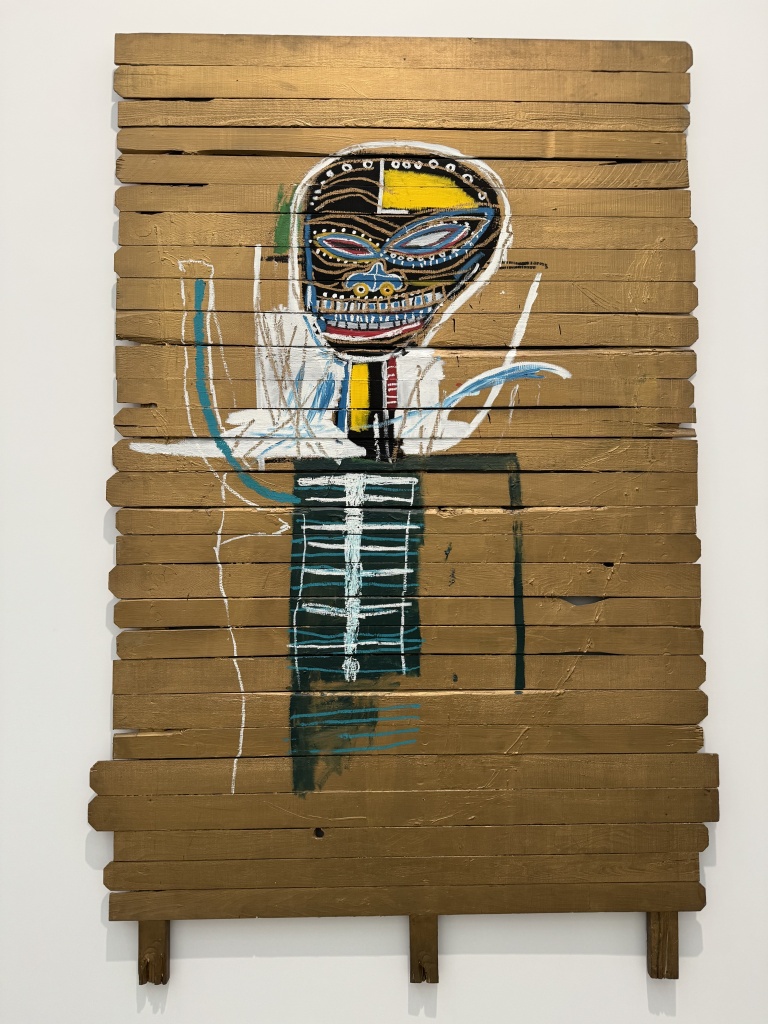 Artwork of a humanoid figure on wooden boards by Jean-Michel Basquiat.