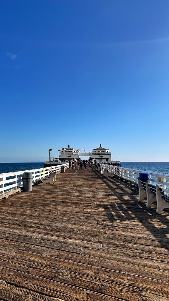A photo from the entrance to a pier showing the straight way to its end.