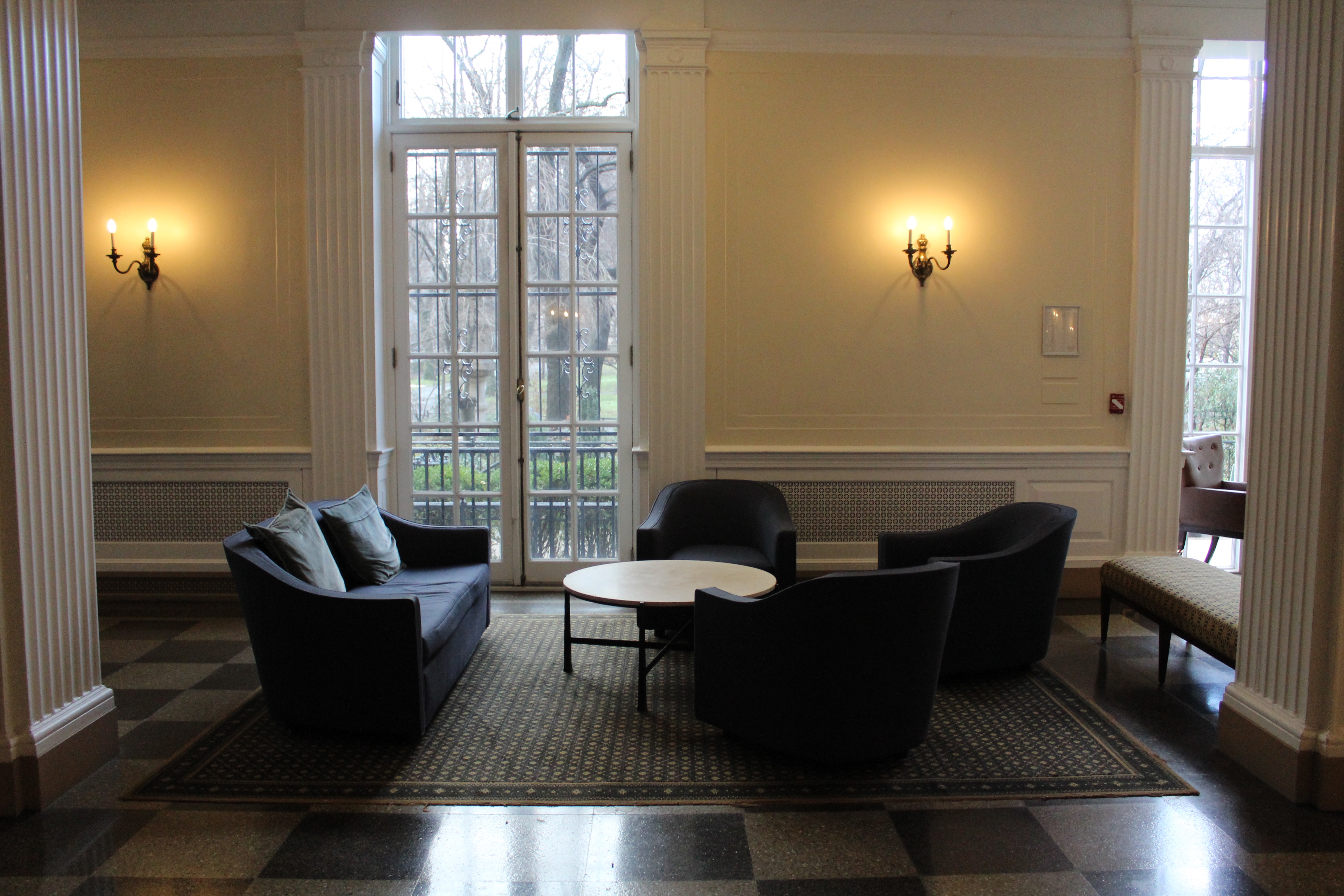 A sofa and three armchairs around a round table.