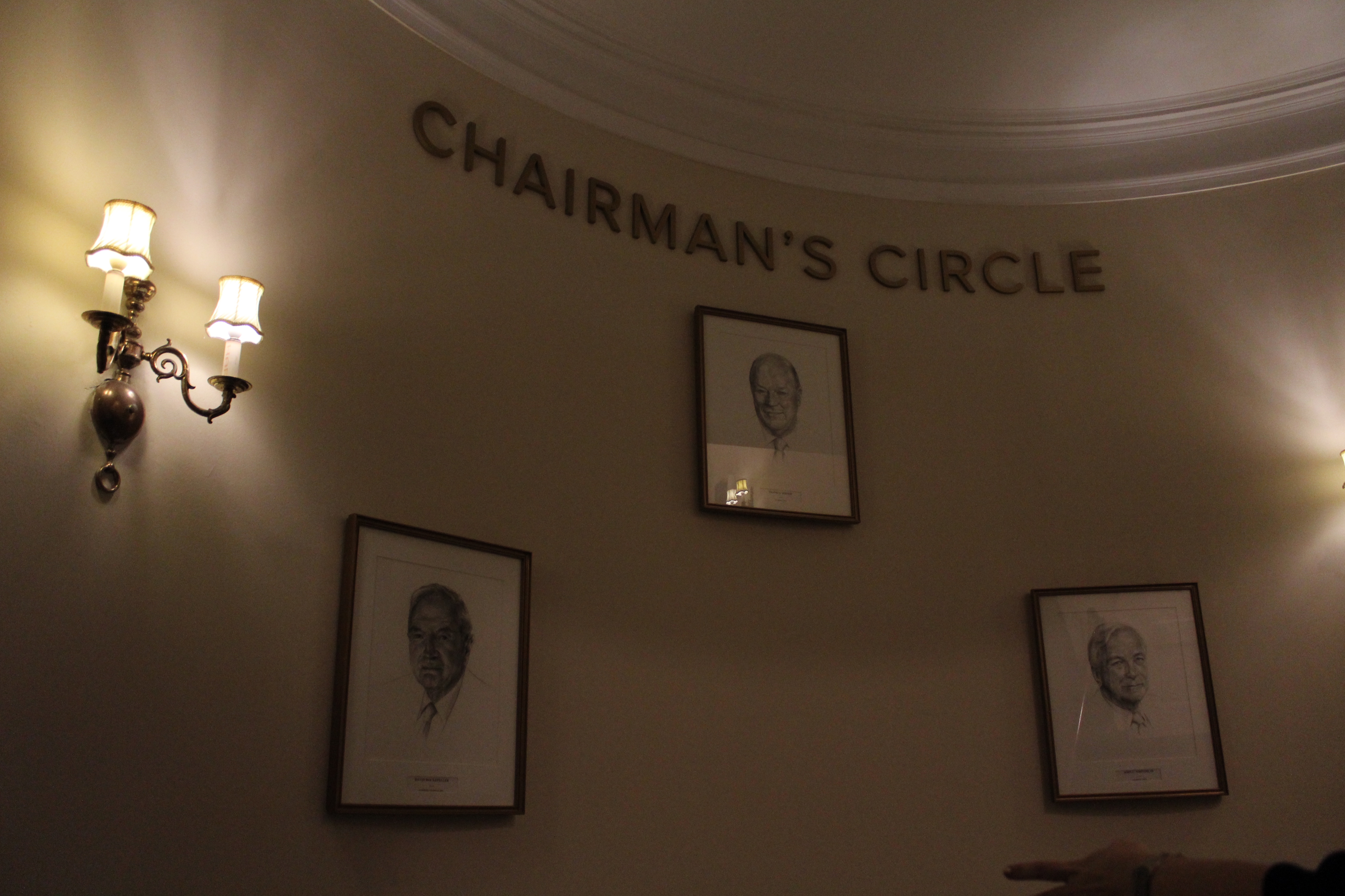A sign reads "Chairman's Circle" with three portraits under it.